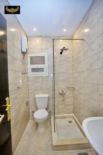 a bathroom with a toilet and a shower and a sink at Comfort Sphinx & Pyramids Inn in Cairo