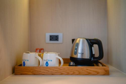 a shelf with two coffee mugs and a toaster on it at BlueSotel Krabi AoNang Beach in Ao Nang Beach