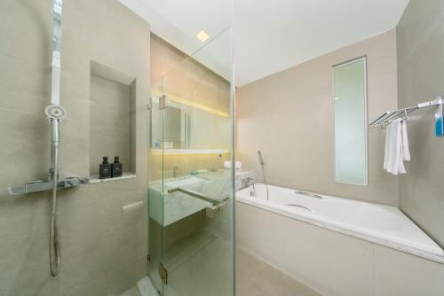 a bathroom with a shower and a tub and a sink at BlueSotel Krabi AoNang Beach in Ao Nang Beach