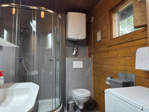 a bathroom with a shower and a toilet and a sink at Blockhäuser auf Reiterhof in Eschede in Eschede