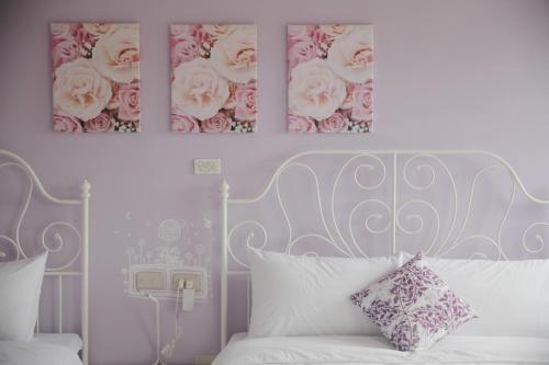 a bedroom with a white bed with pink roses on the wall at Winnie Homestay in Longtian