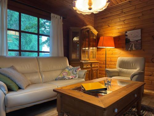 a living room with a couch and a coffee table at Blockhäuser auf Reiterhof in Eschede in Eschede