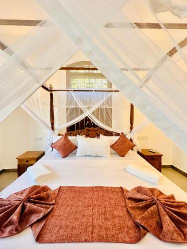 a bedroom with a white bed with a canopy at The Ridge Colonial Villa - Ahangama in Ahangama