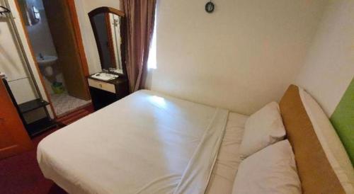 a bedroom with a white bed in a room at OYO 1167 Rest and Go Hotel Klang in Klang