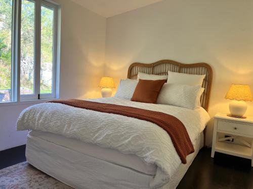 Un dormitorio con una cama grande con dos lámparas. en Nunkeri, en Wollombi
