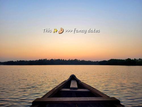 a boat in the middle of a lake at sunset at Munroe Paradise in Munroe Island