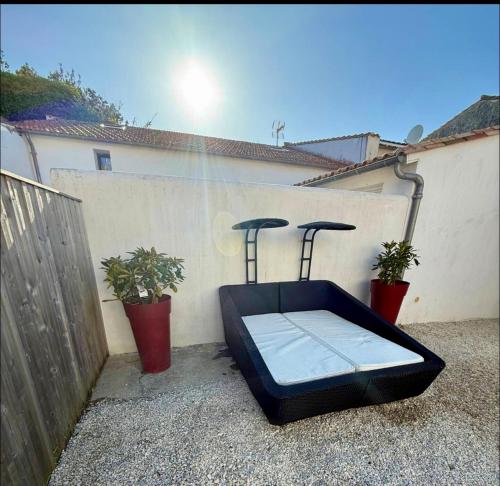 a mattress sitting on the side of a wall with two plants at Maison vue Mer Ile de Ré - Rivedoux-Plage - Villa Raie Manta - Ile de Ré - 4 chambres - 2 salles d eau - 1 à 8 personnes - Plage à pied in Rivedoux-Plage