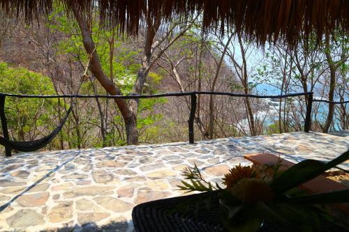 a patio with a table and a chair and trees at Hotel Bahía de la Luna in Arroyo Cruz