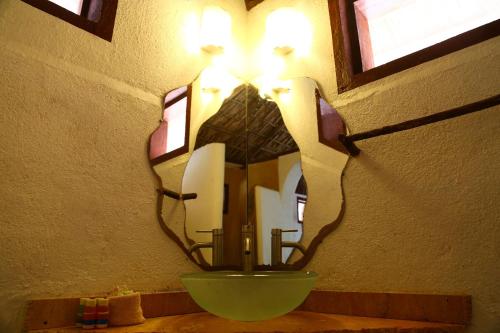 a mirror hanging on a wall with a sink at Hotel Bahía de la Luna in Arroyo Cruz