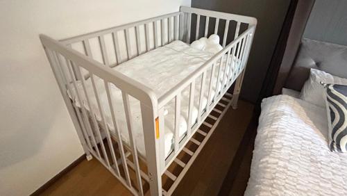a white crib in a room with two beds at YURURIBASE 凛 in Nagahama contactless checkin in Nagahama