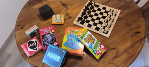 a wooden table with books and chess on it at le refuge des étangs in Vignoux-sur-Barangeon