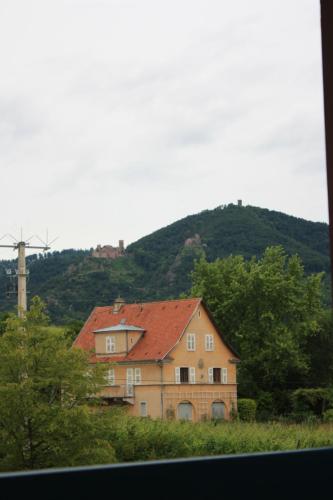 une maison avec un toit rouge en face d'une colline dans l'établissement Gite Le coeur des Ribeaupierres, à Ribeauvillé
