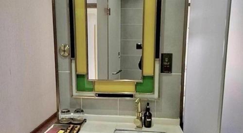 a bathroom with a sink and a mirror at James Joyce Coffetel Xian Big Goose Pagoda Tang Paradise Branch in Xi'an