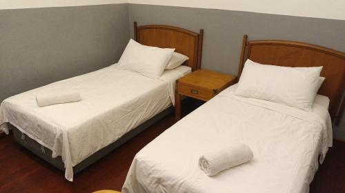 two beds in a small room with two pillows at Heeren Street Boutique Hotel at Jonker Walk in Melaka