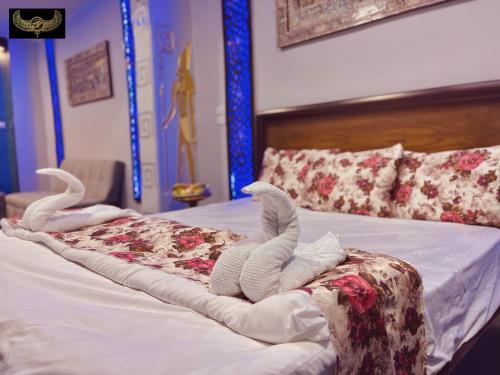 a bed with two stuffed animals laying on it at Comfort Inn Pyramids Hotel in Cairo