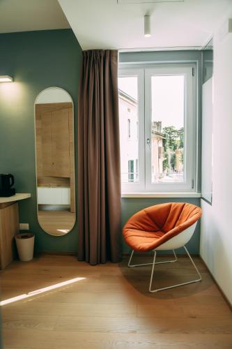 an orange chair in a room with a window at Borgo di Lazise in Lazise