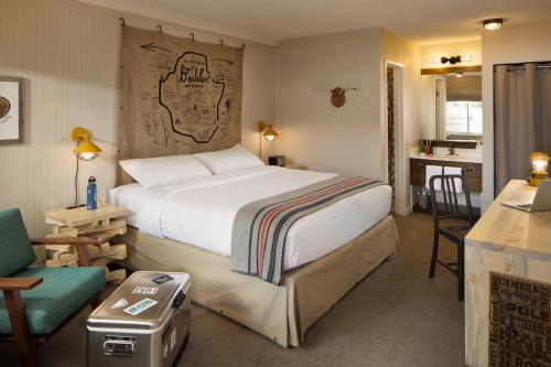 Un dormitorio con una cama y un escritorio y una cocina. en Basecamp Boulder, en Boulder