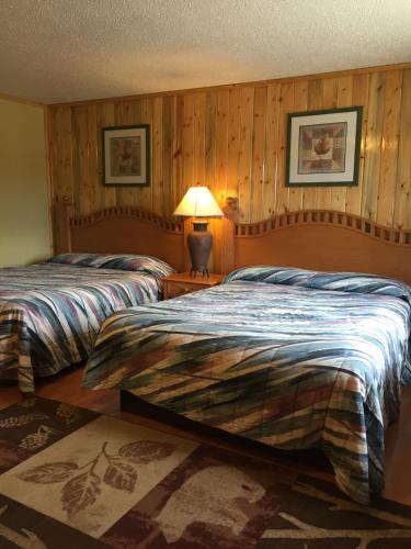 a bedroom with two beds and a lamp on a table at Z Bar Motel in Buffalo
