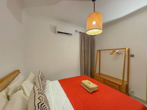 a bedroom with a bed with a red blanket and a mirror at Rumah Tetangga Jogja - 4BR Villa Near Keraton in Ngabean