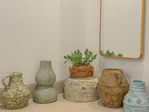 a group of vases sitting on a shelf in a room at Rumah Tetangga Jogja - 4BR Villa Near Keraton in Ngabean