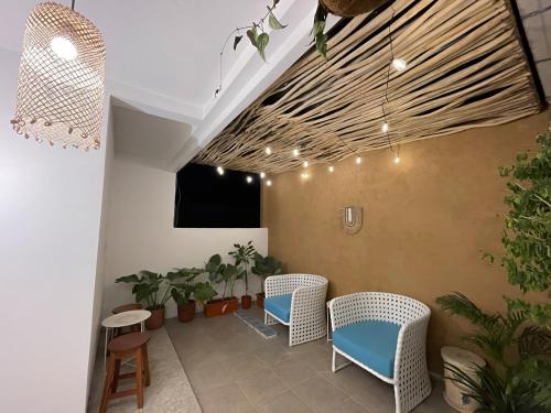 a room with wicker chairs and potted plants at Rumah Tetangga Jogja - 4BR Villa Near Keraton in Ngabean