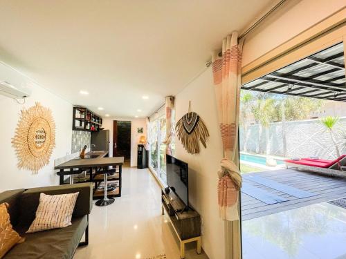 a living room with a couch and a large window at Tropical 2BR Escape & Walk to Selong Belanak Beach in Selong Belanak