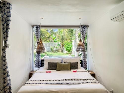 a bed in a room with a window at Tropical 2BR Escape & Walk to Selong Belanak Beach in Selong Belanak