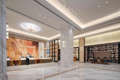 a rendering of a library with people standing in the lobby at Vienna International Hotel Guangzhou 维也纳国际酒店广州宝能香雪地铁站店 in Guangzhou