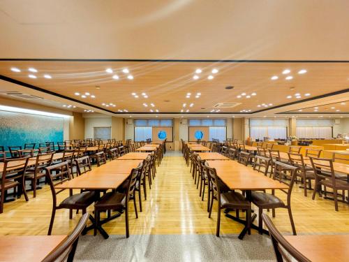 a large lecture hall with tables and chairs at Itoen Hotel Shima in Nakanojo