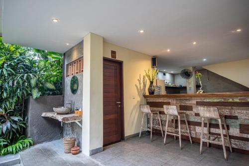 a patio with a bar and some stools at Merak Village by Prasi in Ubud