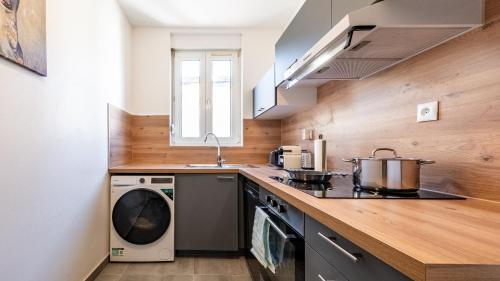 a kitchen with a stove and a washing machine at Appart Cocooning 6 Personnes Hyper Centre Mulhouse in Mulhouse