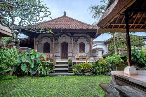 a house with a garden with stairs leading to it at Merak Village by Prasi in Ubud