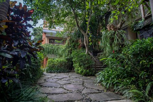 a stone walkway in front of a building at Merak Village by Prasi in Ubud