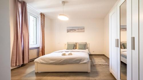 a bedroom with a bed with two shoes on it at Appart Cocooning 6 Personnes Hyper Centre Mulhouse in Mulhouse