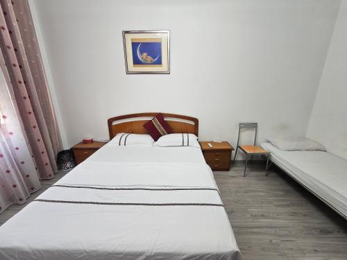 a bedroom with two beds and a picture on the wall at YiJia - Locazione Turistica in Padova