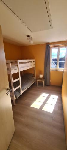a room with two bunk beds and a window at La maison du tonnelier in Cleebourg