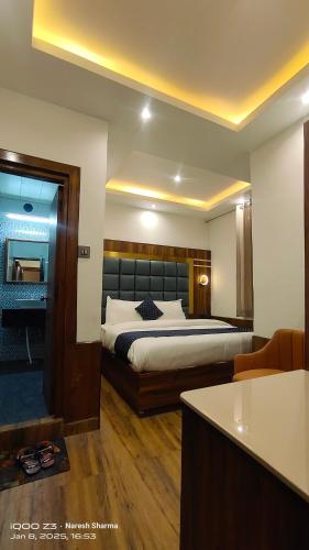 a hotel room with a bed and a kitchen at Magic Stays Simla Royale - Near Mall Road Free Pickup from railway station Shiimla in Shimla