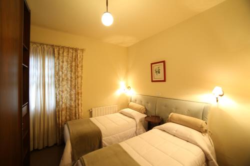 um quarto de hotel com duas camas e uma janela em Europa Hotel em Campos do Jordão