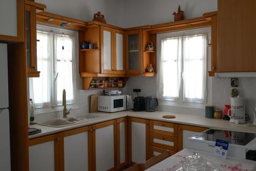 a kitchen with wooden cabinets and a microwave at Kamares Bay View in Sifnos