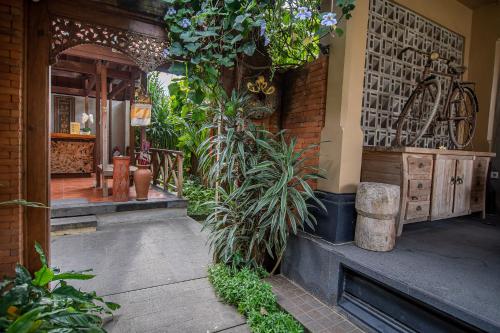 a porch of a house with plants on it at Merak Village by Prasi in Ubud
