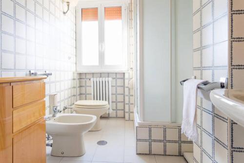 a bathroom with two toilets and a sink and a window at Smile House in Matera