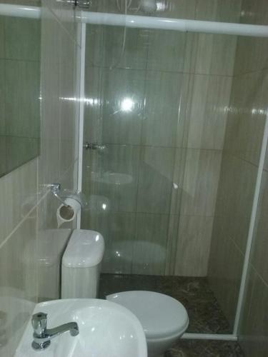 a bathroom with a shower and a toilet and a sink at Trilhos Hotel in Sao Paulo