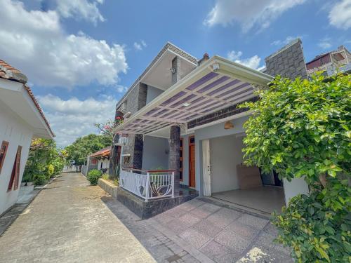 a house with a porch with awning on it at Rumah Tetangga Jogja - 4BR Villa Near Keraton in Ngabean