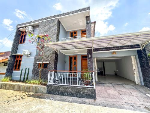 a white house with a balcony in front of it at Rumah Tetangga Jogja - 4BR Villa Near Keraton in Ngabean