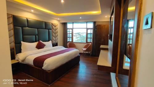 a bedroom with a large bed in a room at Magic Stays Simla Royale - Near Mall Road Free Pickup from railway station Shiimla in Shimla
