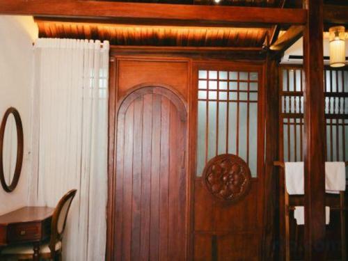 a wooden door in a room with a white curtain at Jun's Home in Buon Ma Thuot
