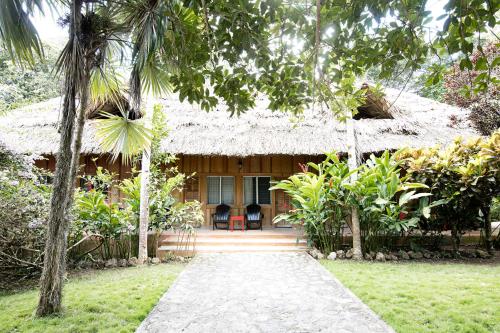 a house with a pathway in front of it at Jungle Lodge Tikal Hostal in Tikal
