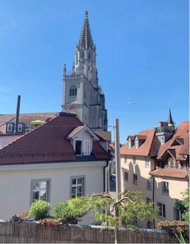 a building with a clock tower in a city at Ferienwohnung ATELIER MÜNSTERBLICK in Konstanz