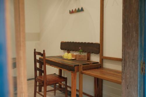 a wooden table with a chair and a table with a box at Dreamville Beach Homestay in Phu Yen