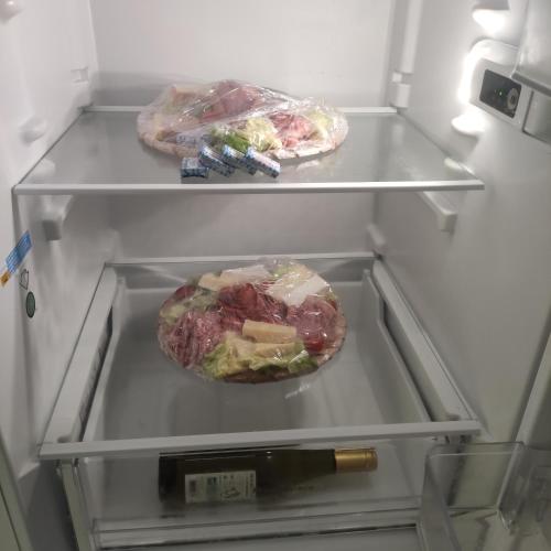 an open refrigerator with a bottle of wine in it at LA PETITE GRANGE in Fresnes-Tilloloy